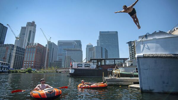 Мужчина ныряет в воду в лондонском районе Доклендс, Англия - Sputnik Латвия