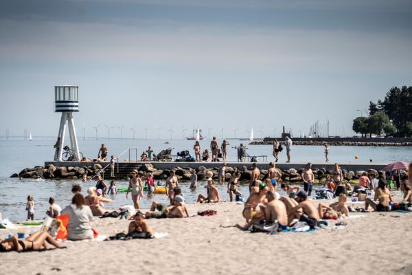Люди наслаждаются жаркой погодой на пляже Бельвю к северу от Копенгагена, Дания - Sputnik Латвия