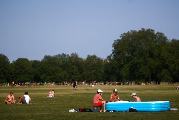 Люди отдыхают в надувном бассейне в Лондоне, Великобритания - Sputnik Латвия