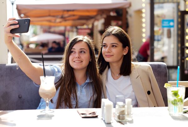 Девушки в летнем кафе на улице Старый Арбат после снятия карантина в Москве - Sputnik Латвия