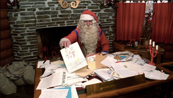 Санта Клаус в своей резиденции разбирает рождественскую почту - Sputnik Латвия