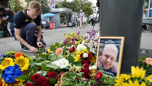 Мужчина зажигает свечу на том месте, где журналист Павел Шеремет был убит в результате взрыва - Sputnik Латвия