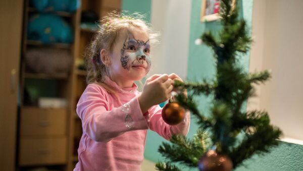 Девочка наряжает новогоднюю ёлку - Sputnik Латвия