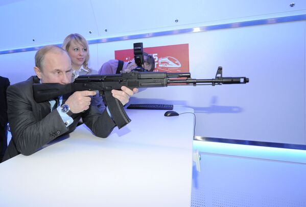 2012. gada 26. aprīlis. Krievijas valdības vadītājs, Krievijas prezidenta postenī ievēlētais Vladimirs Putins ar automāta AK-74 maketu šauj mērķī pārvietojamā izstāžu un lekciju kompleksa  elektroniskajā šautuvē, apmeklējot AAS Krievijas dzelzceļš Zinātniski tehniskās attīstības centru. - Sputnik Latvija
