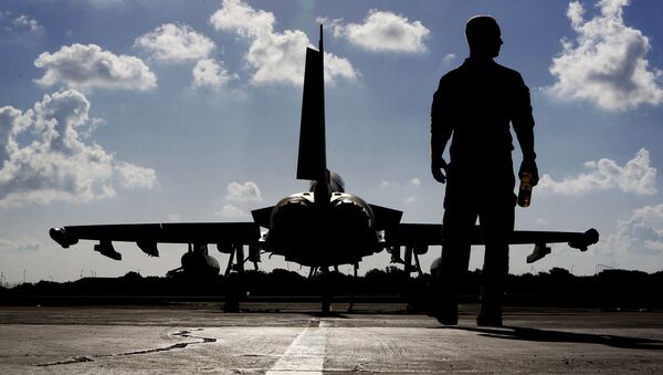 Британский солдат рядом с самолетом Typhoon на авиабазе Акротири, недалеко от Южного прибрежного города Лимассол на Кипре - Sputnik Latvija