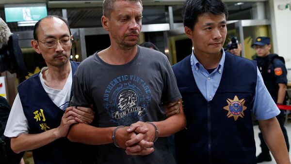 Тайваньские полицейские конвоируют задержанного латвийца Андрейса Перегудовса - Sputnik Латвия