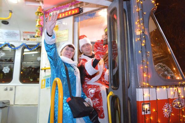 Водитель в костюме Деда Мороза и кондуктор в костюме Снегурочки в новогоднем трамвае в Краснодаре - Sputnik Латвия