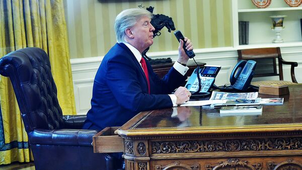 Президент США Дональд Трамп говорит по телефону в овальном кабинете - Sputnik Латвия