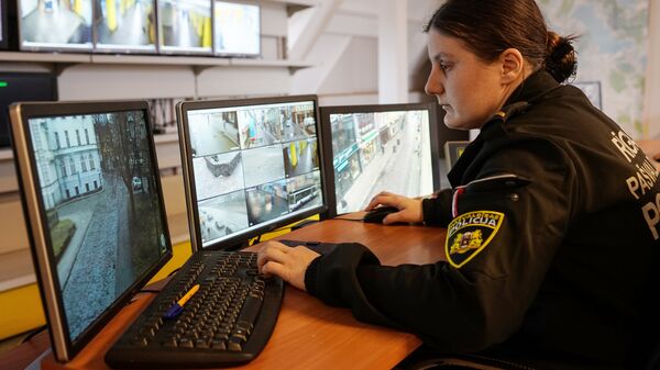 Сотрудница полиции ведет наблюдение за видеокамерами в Старой Риге Сотрудница полиции ведет наблюдение за видеокамерами в Старой Риге - Sputnik Латвия