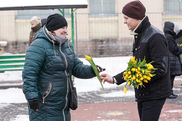 Парень поздравляет женщину с 8 Марта на Центральном рынке - Sputnik Латвия