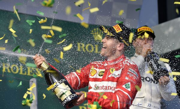 Немецкий пилот Ferrari Себастьян Феттель празднует победу в Гран-при Австралии в Мельбурне - Sputnik Латвия