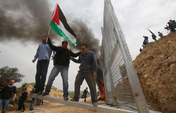 Палестинские демонстранты ломают израильский забор во время протеста в городе Бейт-Джала - Sputnik Латвия