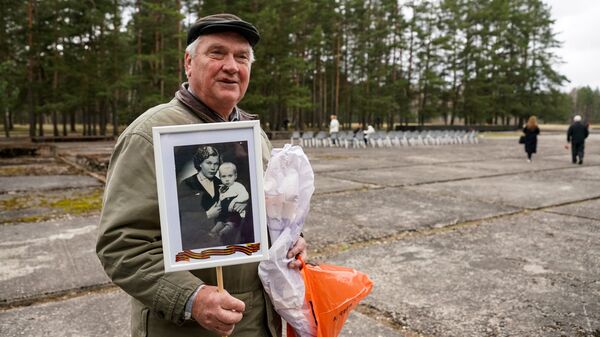 Узник концлагеря демонстрирует свою фотографию с матерью Узник концлагеря демонстрирует свою фотографию с матерью - Sputnik Латвия