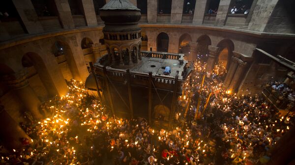 Православные верующие держат свечи во время церемонии в Храме Гроба Господня в Иерусалиме - Sputnik Латвия