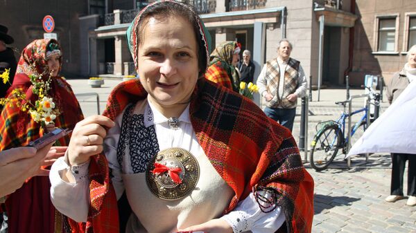Эксперт по национальным костюмам и одна из организаторов шествия Зиедите Музис в традиционном наряде Курземского края Эксперт по национальным костюмам и одна из организаторов шествия Зиедите Музис в традиционном наряде Курземского края - Sputnik Латвия