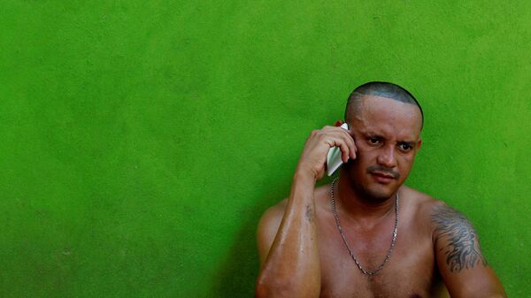 Мигрант разговаривает по мобильному телефону - Sputnik Латвия