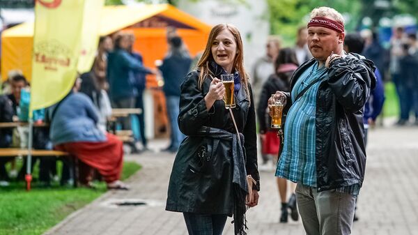 Посетители пивного фестиваля дегустируют пенный напиток Посетители пивного фестиваля дегустируют пенный напиток - Sputnik Латвия
