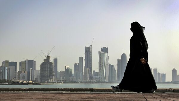 Катарская женщина идет на фоне города Доха - Sputnik Latvija
