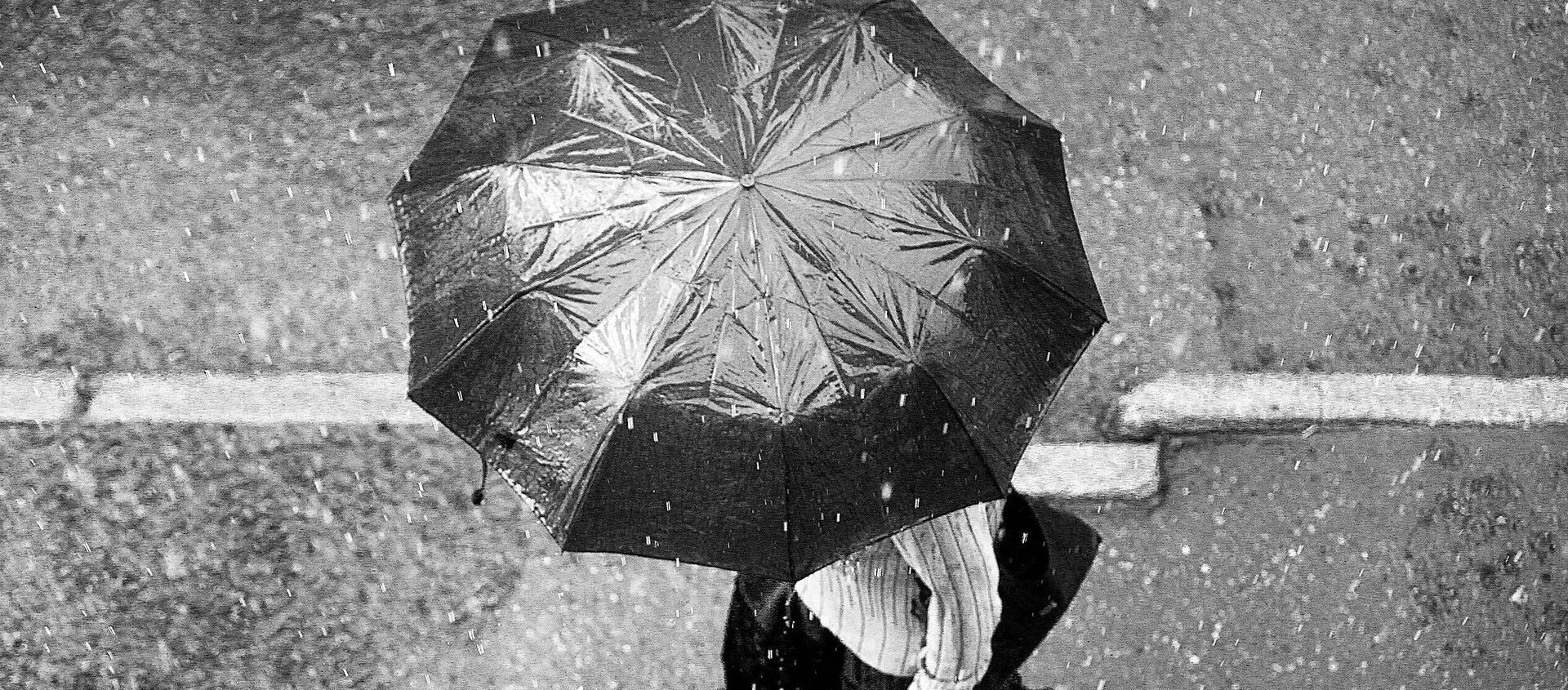 Человек с зонтиком под дождем - Sputnik Латвия, 1920, 02.05.2021