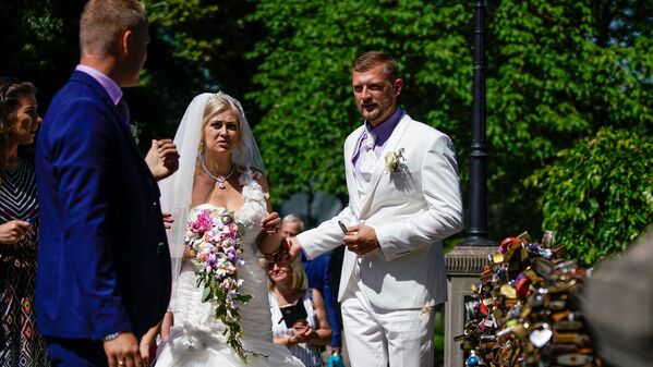 Līgavainis ar līgavu pēc tradīcijas aizslēdz slēdzeni uz tiltiņa Bastejkalnāе - Sputnik Latvija