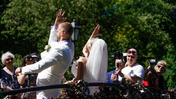 Līgavainis ar līgavu pēc tradīcijas izmet atslēgas Rīgas kanālā - Sputnik Latvija
