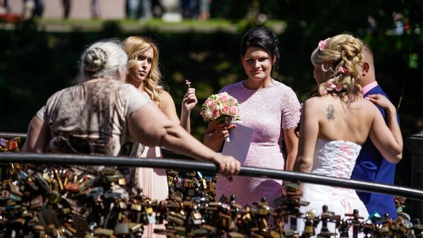Līgavainis ar līgavu pēc tradīcijas aizslēdz slēdzeni uz tiltiņa Bastejkalnā - Sputnik Latvija