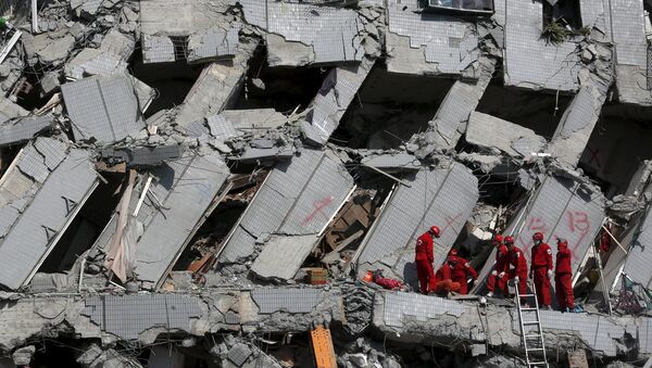Спасатели работают на месте рухнувшего 17-этажного жилого дома в Тайнань - Sputnik Латвия