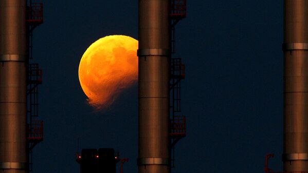Восходящая луна  во время частичного лунного затмения за трубами электростанции в Делимаре, недалеко от Мальты - Sputnik Латвия