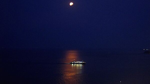 Луна, наблюдаемая в частичном лунном затмении над кораблем на острове Закинтос - Sputnik Латвия