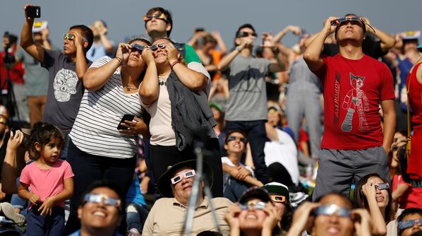 Люди наблюдают за солнечным затмением на лужайке обсерватории Гриффита в Лос-Анджелесе - Sputnik Латвия