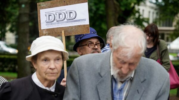 Мужчина с плакатом латышской газеты DDD - декоммунизация, деколонизация, дебольшевизация Мужчина с плакатом латышской газеты DDD - декоммунизация, деколонизация, дебольшевизация - Sputnik Латвия