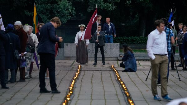 Символический огненный путь из свечек на акции памяти начала третьей Атмоды в Риге Символический огненный путь из свечек на акции памяти начала третьей Атмоды в Риге - Sputnik Латвия