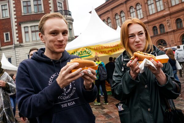 Гости фестиваля дегустируют хот-доги - Sputnik Латвия