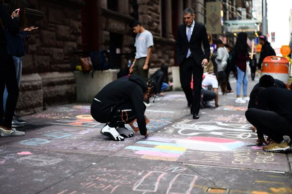 Учащиеся рисуют башни-близнецы и пишут сообщения на тротуаре перед своей школой 11 сентября 2017 года в Нью-Йорке в связи с 16-й годовщиной терактов - Sputnik Латвия
