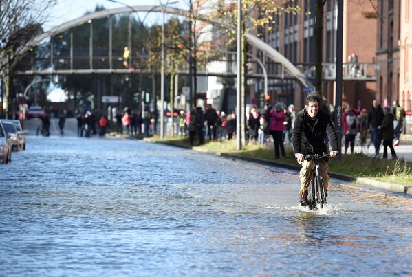 Велосипедист на затопленной улице во время шторма Герварт в Германии - Sputnik Латвия