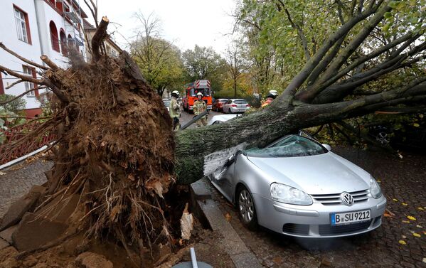 Пожарные рядом с упавшим на машину деревом в результате шторма Герварт в Берлине, Германия - Sputnik Латвия