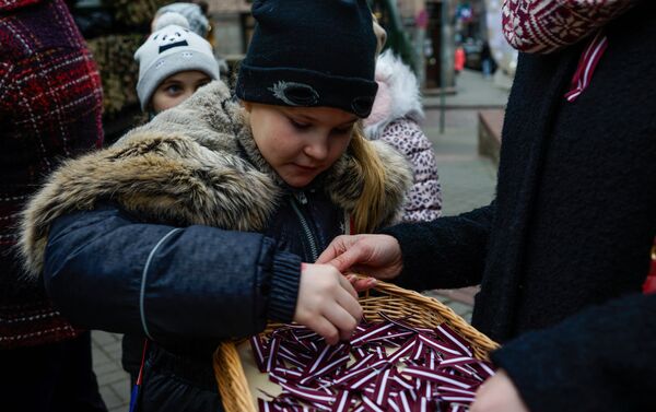 Девочка берет ленточку в цветах латвийского флага - Sputnik Латвия