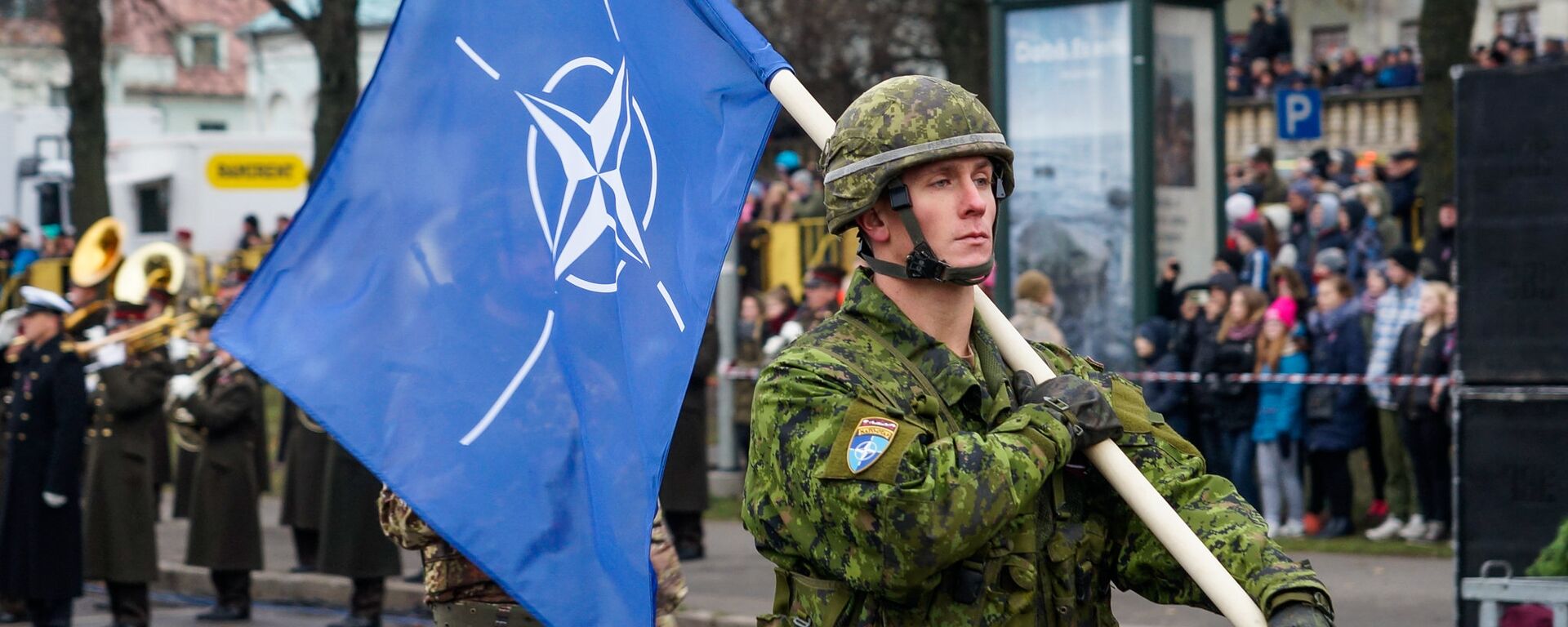 Военнослужащий Канады несет флаг НАТО на военном параде в Риге - Sputnik Латвия, 1920, 21.12.2021