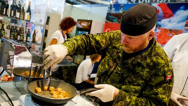 Канадский военный из сводного батальона НАТО в Латвии готовит гребешки - Sputnik Latvija