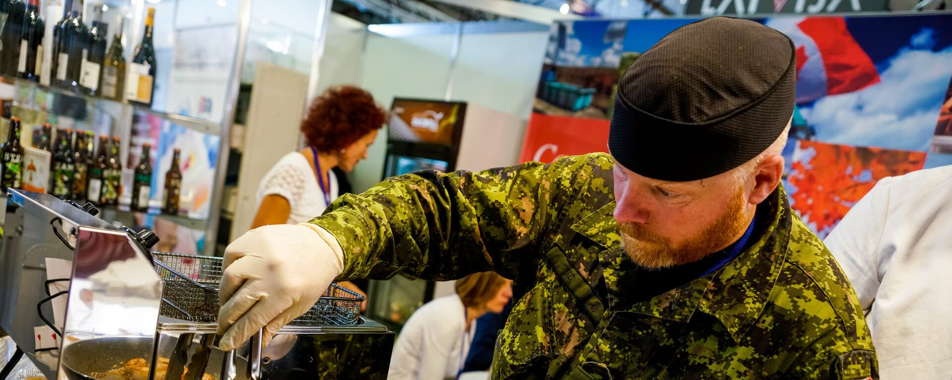 Канадский военный из сводного батальона НАТО в Латвии готовит гребешки - Sputnik Латвия, 1920, 02.08.2019