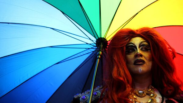 Член ЛГБТ-сообщества с зонтиком во время парада - Sputnik Латвия