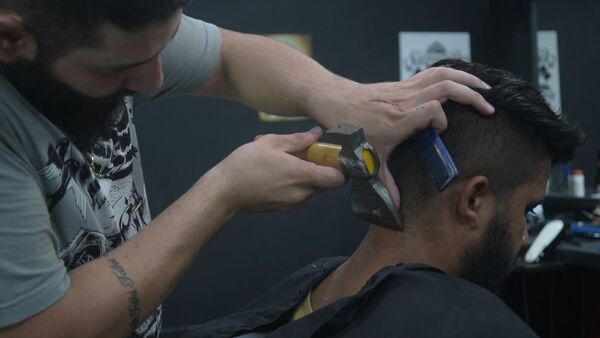 Сирийский беженец открыл в Бразилиа парикмахерскую, где стрижет людей с помощью топора - Sputnik Latvija
