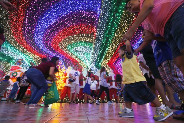 Filipinos pose as they tour the inside of the Christmas House owned by businessman Alexander Cruz in suburban Cainta, Rizal province east of Manila, Philippines - Sputnik Латвия