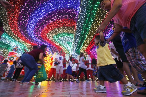 Filipinos pose as they tour the inside of the Christmas House owned by businessman Alexander Cruz in suburban Cainta, Rizal province east of Manila, Philippines Filipinos pose as they tour the inside of the Christmas House owned by businessman Alexander Cruz in suburban Cainta, Rizal province east of Manila, Philippines - Sputnik Latvija