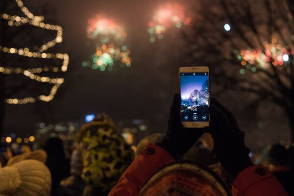 Женщина снимает на телефон Новогодний салют - Sputnik Латвия