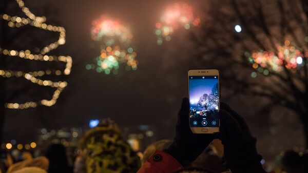Женщина снимает на телефон Новогодний салют - Sputnik Latvija