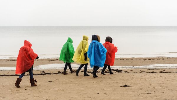 Девушки в дождевиках на пляже Юрмалы - Sputnik Латвия