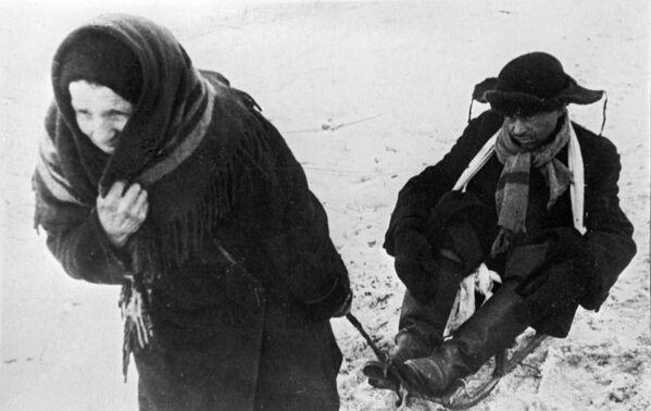 Женщина везет ослабевшего от голода мужа в дни блокады Ленинграда Женщина везет ослабевшего от голода мужа в дни блокады Ленинграда - Sputnik Латвия