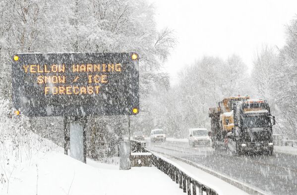 Грузовик проезжает мимо знака, предупреждающего о неблагоприятных погодных условиях на трассе A9 в Килликранки, Шотландия - Sputnik Латвия