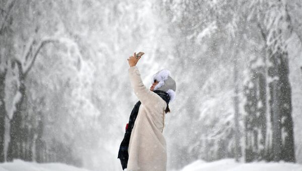 Девушка фотографируется во время снегопада - Sputnik Латвия
